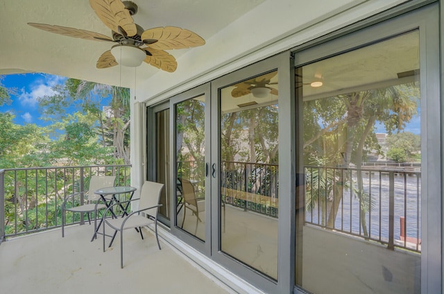 unfurnished sunroom with ceiling fan