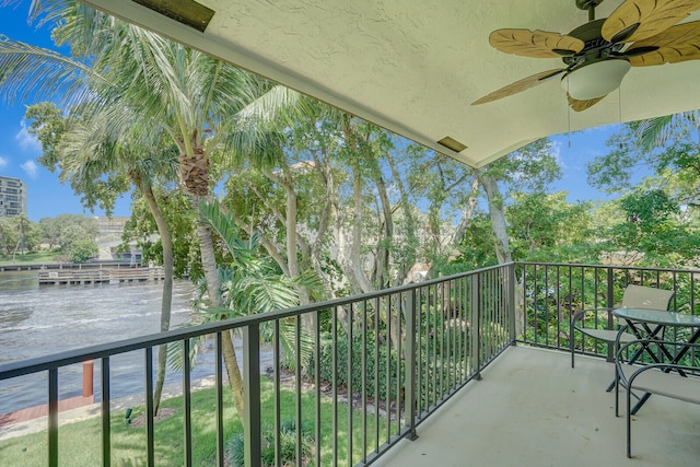 balcony featuring ceiling fan and a water view