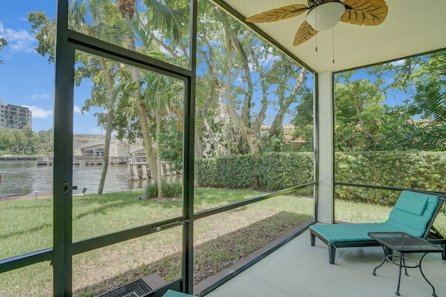 sunroom / solarium featuring a wealth of natural light, a water view, and ceiling fan