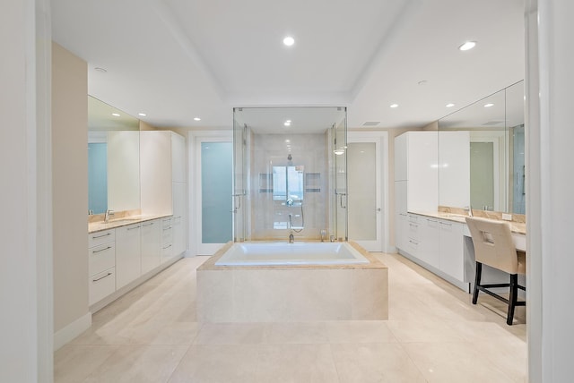 bathroom with two vanities, a stall shower, a sink, recessed lighting, and a bath