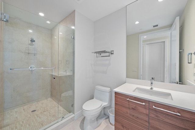 bathroom with tile patterned flooring, vanity, a shower with shower door, and toilet