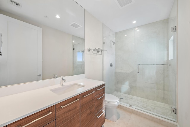 bathroom with tile patterned floors, vanity, toilet, and a shower with door