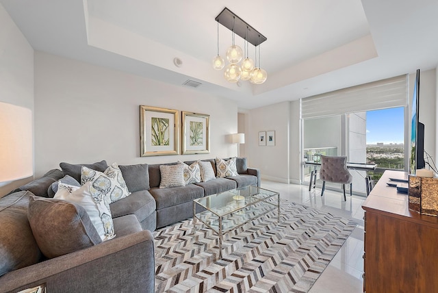 living area featuring light tile patterned floors, baseboards, visible vents, a raised ceiling, and a notable chandelier