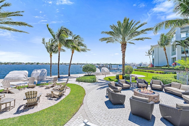 view of patio with an outdoor fire pit and a water view