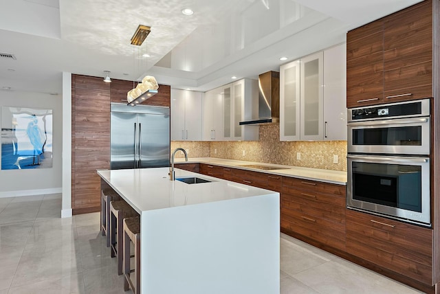 kitchen featuring backsplash, modern cabinets, a sink, light countertops, and beverage cooler