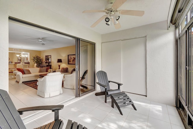 interior space featuring ceiling fan with notable chandelier