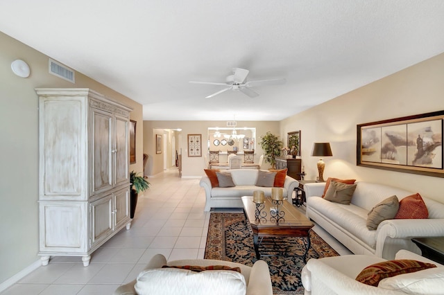 living room with ceiling fan with notable chandelier and light tile patterned floors