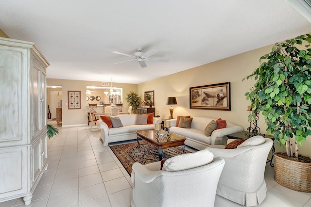 tiled living room featuring ceiling fan with notable chandelier