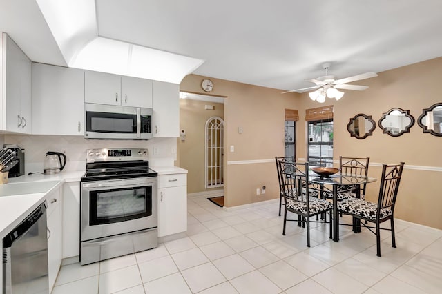 kitchen featuring backsplash, ceiling fan, light tile patterned flooring, white cabinetry, and stainless steel appliances