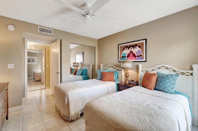 bedroom featuring light tile patterned flooring, a textured ceiling, a closet, and ceiling fan