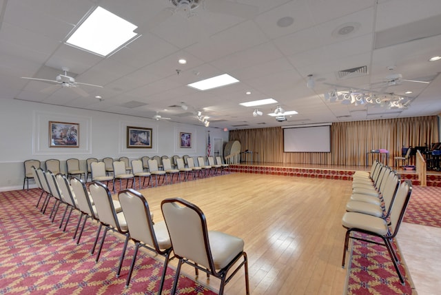 interior space featuring a paneled ceiling, ceiling fan, and light wood-type flooring