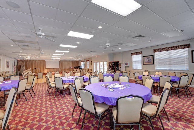 dining area featuring carpet, a drop ceiling, and ceiling fan