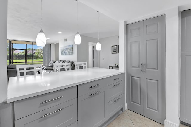 kitchen featuring decorative light fixtures, gray cabinets, and light tile patterned flooring