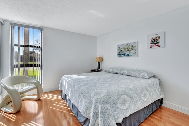 bedroom featuring hardwood / wood-style floors and a textured ceiling