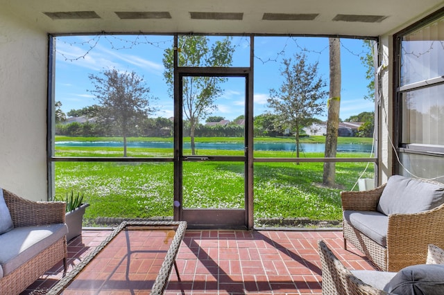 sunroom featuring a water view