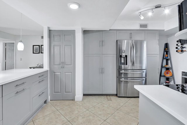 kitchen featuring gray cabinetry, stainless steel fridge with ice dispenser, light tile patterned floors, and pendant lighting