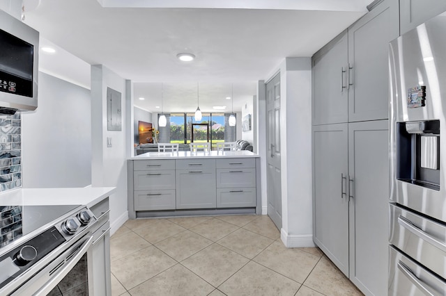 kitchen featuring decorative backsplash, gray cabinets, light tile patterned floors, and stainless steel appliances