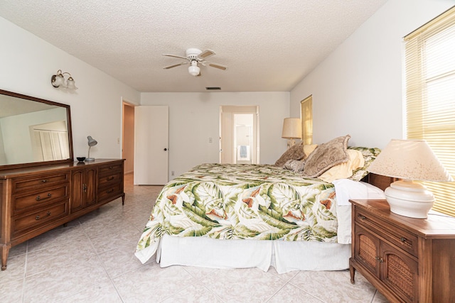 bedroom with ceiling fan and a textured ceiling