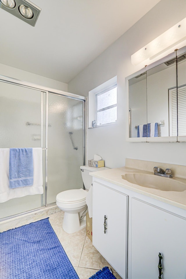 bathroom with tile patterned flooring, vanity, an enclosed shower, and toilet