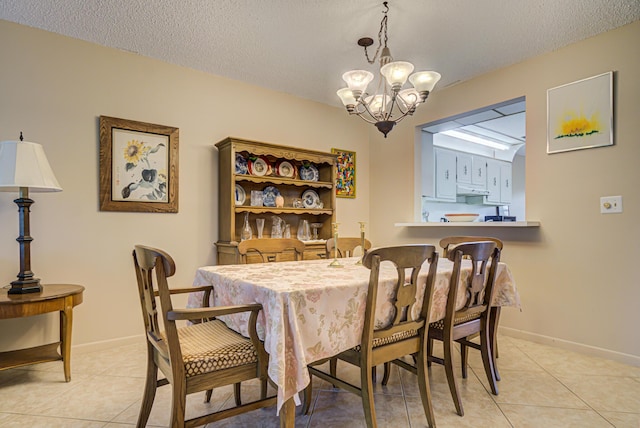 dining space with light tile patterned floors, a textured ceiling, and an inviting chandelier