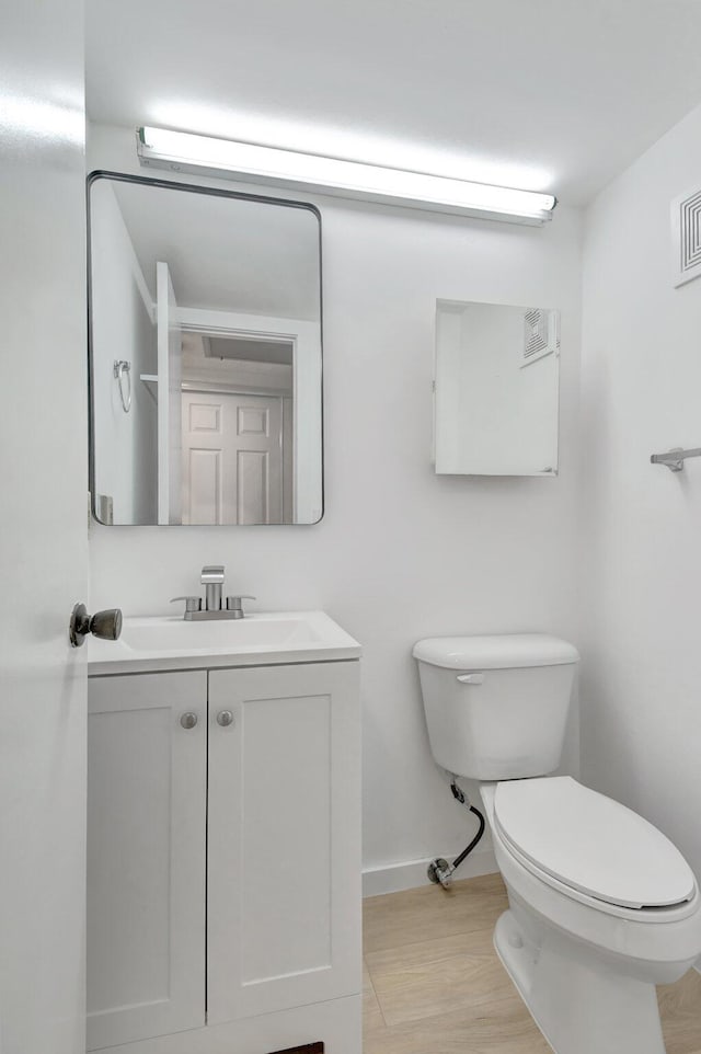 bathroom with vanity, wood-type flooring, and toilet