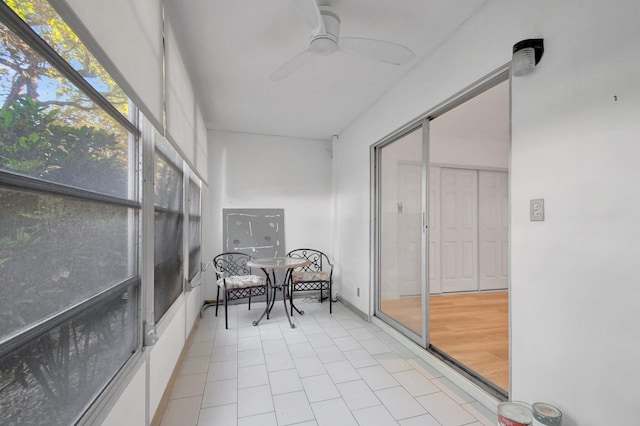 unfurnished sunroom with ceiling fan