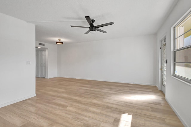 unfurnished room featuring ceiling fan, light hardwood / wood-style flooring, and a textured ceiling