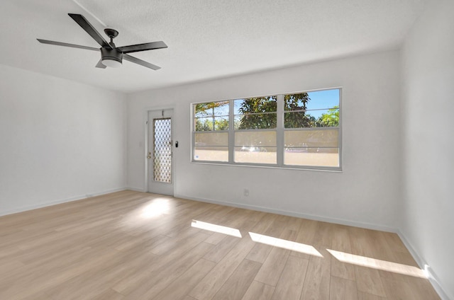 unfurnished room with ceiling fan, a textured ceiling, and light wood-type flooring