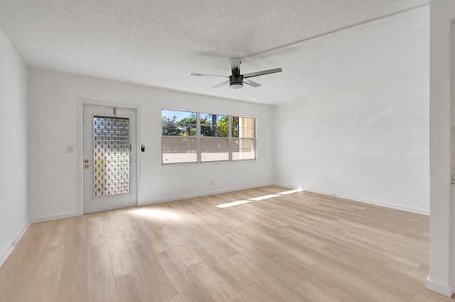 spare room with ceiling fan, a textured ceiling, and light hardwood / wood-style flooring