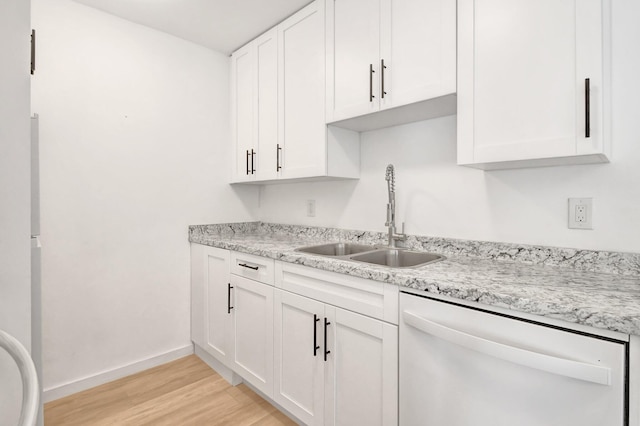 kitchen featuring sink, stainless steel dishwasher, light hardwood / wood-style floors, light stone counters, and white cabinetry