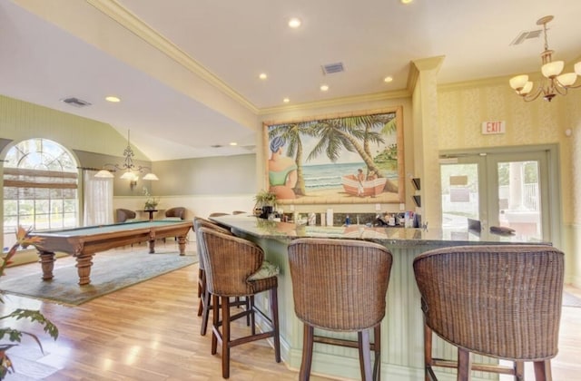 bar with french doors, billiards, hanging light fixtures, ornamental molding, and light hardwood / wood-style floors