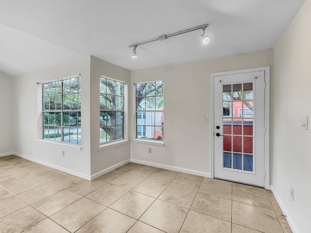 interior space featuring track lighting and light tile patterned floors