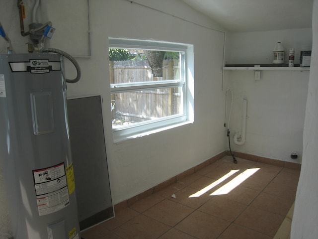 washroom featuring tile patterned floors, a wealth of natural light, and water heater