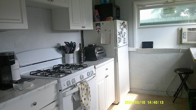 kitchen featuring white cabinetry, light tile patterned floors, and white appliances