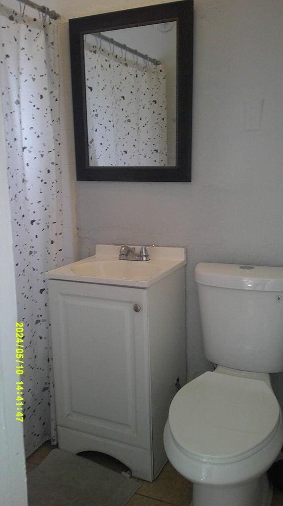 bathroom featuring tile patterned floors, vanity, and toilet