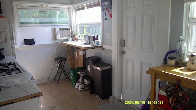 interior space with white range with gas stovetop and light tile patterned flooring