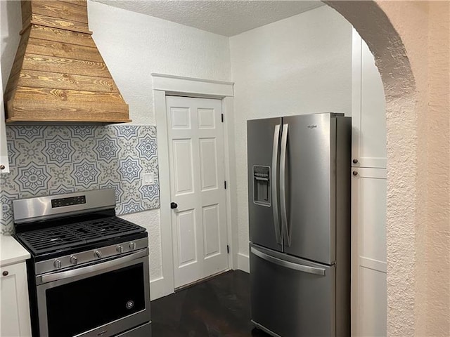 kitchen with stainless steel appliances, tasteful backsplash, dark hardwood / wood-style flooring, a textured ceiling, and white cabinets