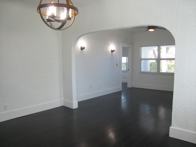 empty room featuring dark hardwood / wood-style floors and a notable chandelier