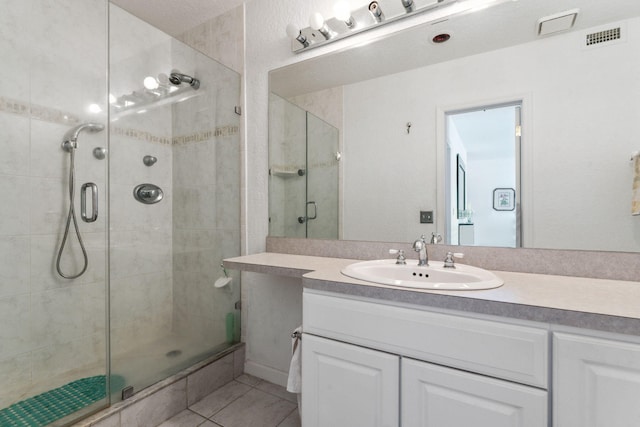 bathroom with tile patterned floors, vanity, and walk in shower