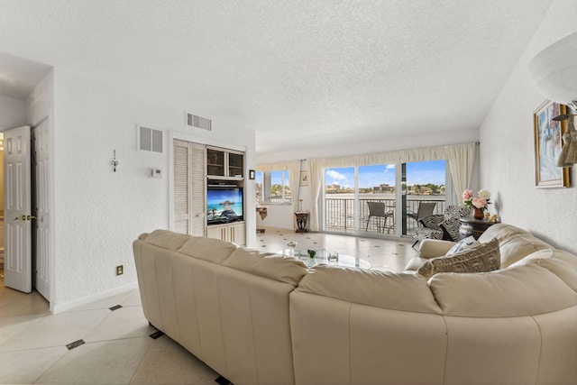 living room with light tile patterned flooring and a textured ceiling