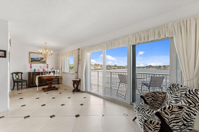 interior space featuring a water view, a textured ceiling, and a chandelier