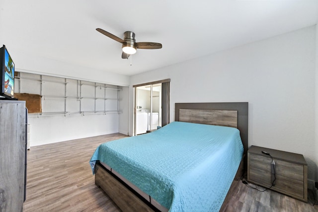 bedroom featuring hardwood / wood-style floors, ceiling fan, and washing machine and clothes dryer