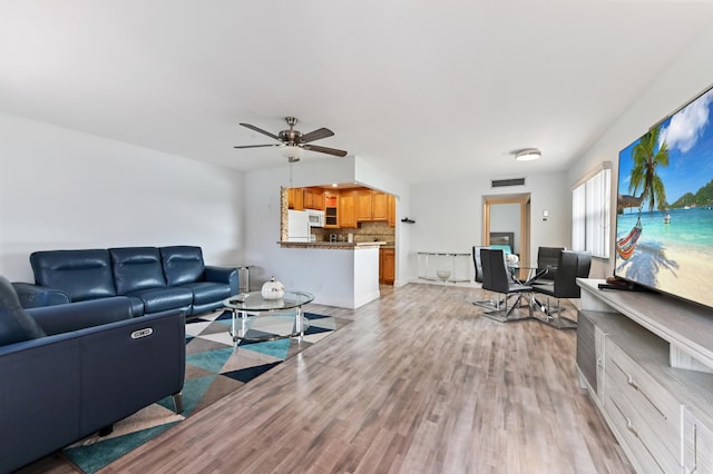 living room featuring ceiling fan and light hardwood / wood-style floors