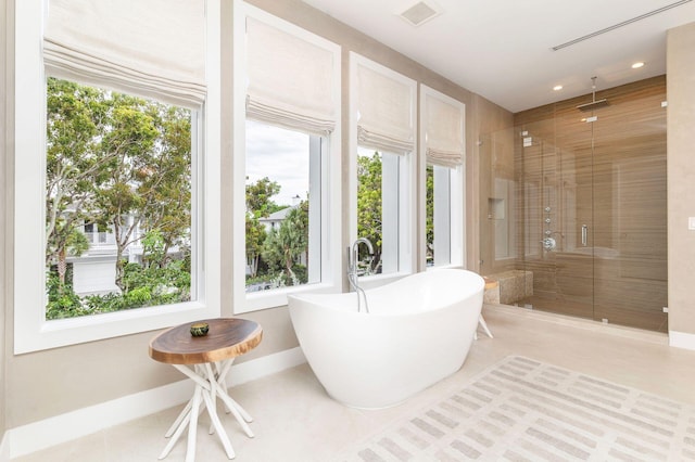 bathroom with tile patterned floors and shower with separate bathtub