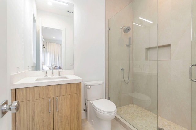 bathroom with vanity, a shower with shower door, and toilet