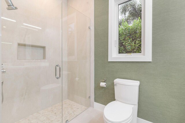 bathroom with toilet and an enclosed shower