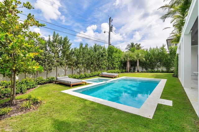 view of pool with a lawn and an in ground hot tub