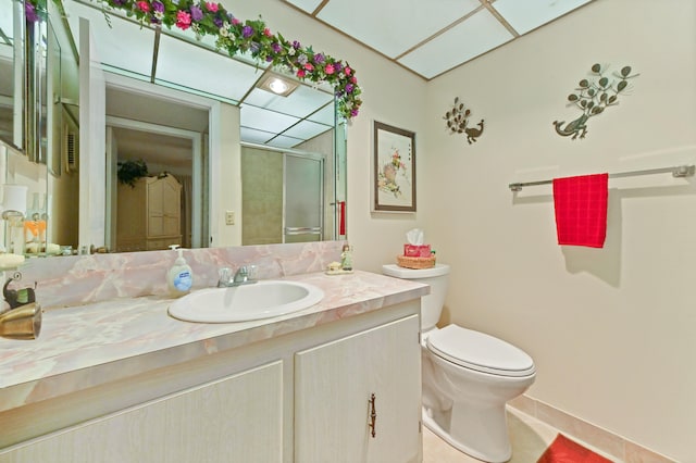 bathroom with vanity, toilet, and a shower with door