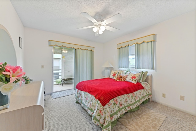 carpeted bedroom with a textured ceiling, multiple windows, and ceiling fan