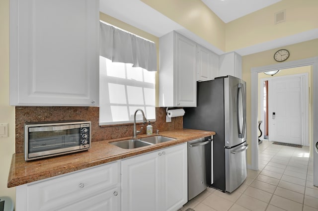 kitchen featuring white cabinets, light tile patterned floors, sink, and stainless steel appliances